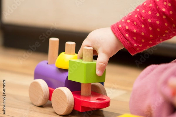 Obraz Baby's hand playing with wooden toy