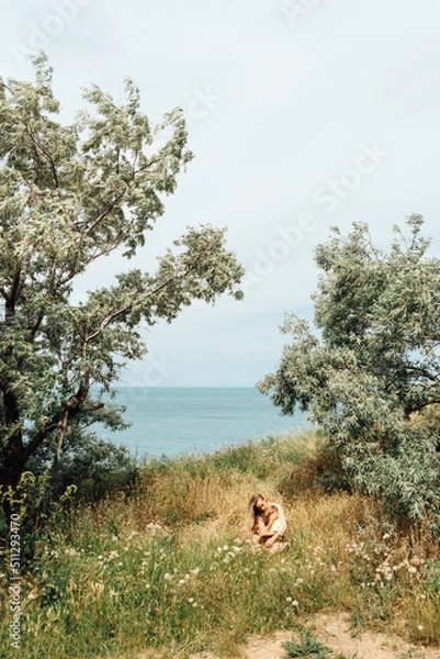 Obraz Mother with son sit among beautiful landscape and hugging