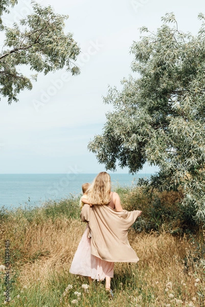 Obraz Blond beautiful Mother with her son go to ocean back view
