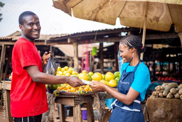 Obraz young African black man paying for grocery in a local african market