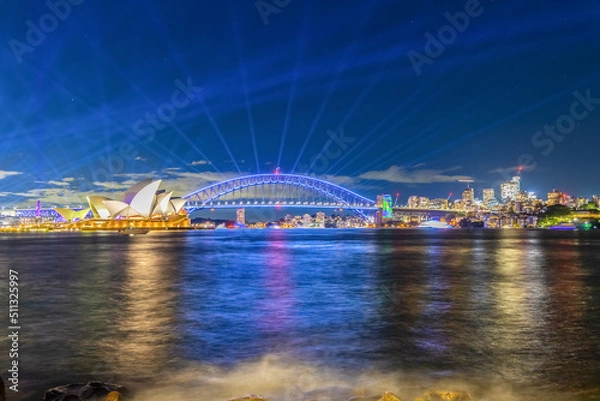 Fototapeta Colourful Light show at night on Sydney Harbour NSW Australia. The bridge illuminated with lasers and neon coloured lights 