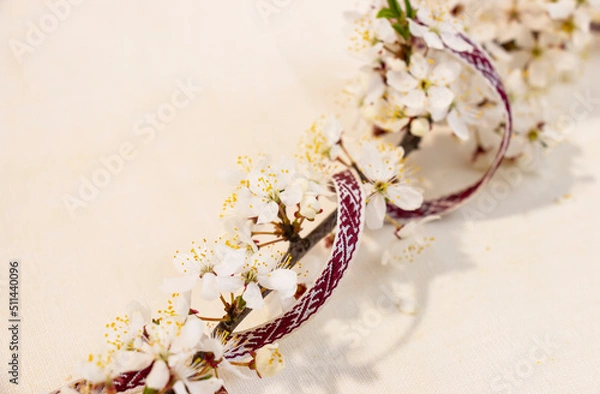 Fototapeta Latvian National Festive Decoration with Blooming Branch from the Ribbon of the Latvian Ribbon Belt Lielvarde for the Independence Day of Latvia