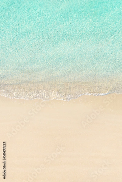 Fototapeta Aerial view of yellow umbrella on sandy beach. Summer and travel concept. Blue, turquoise transparent water surface of ocean, sea, lagoon. Aerial, drone view. vertical