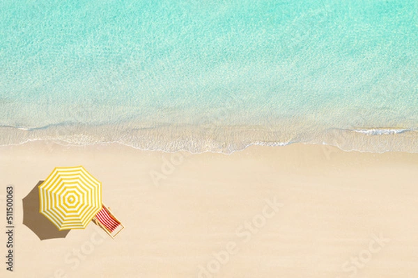 Fototapeta Aerial view of wooden sunbed, lounge, yellow umbrella on sandy beach. Summer and travel concept. Blue, turquoise transparent water surface of ocean, sea, lagoon. Aerial, drone view