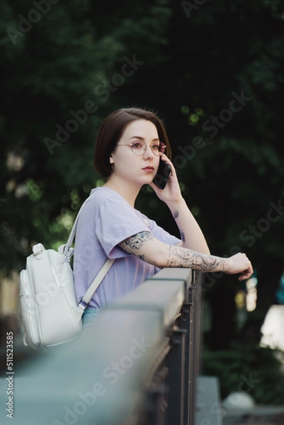 Fototapeta Young Girl Talks on Phone on Street in City Center