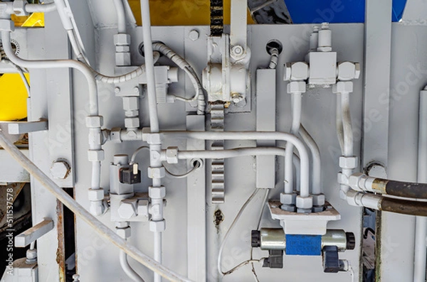 Fototapeta Connection of pipes. Part of production equipment. Hoses, pipes. Part of the machine for the production of paving stones. Close-up.