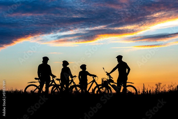 Fototapeta Silhouette four 4 cyclist at sunset. family on cycle ride in countryside