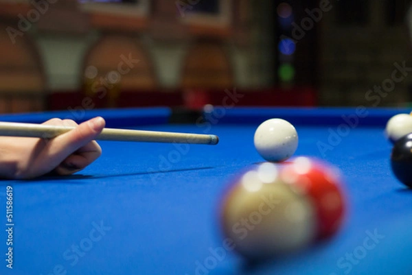 Obraz Eight-ball pool player aims to shoot balls with cue