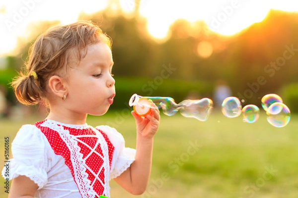 Obraz Child blowing soap bubbles.
