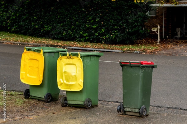 Fototapeta Australian garbage wheelie bins with colourful lids for recycling and general household waste lined up on the street for council rubbish collection
