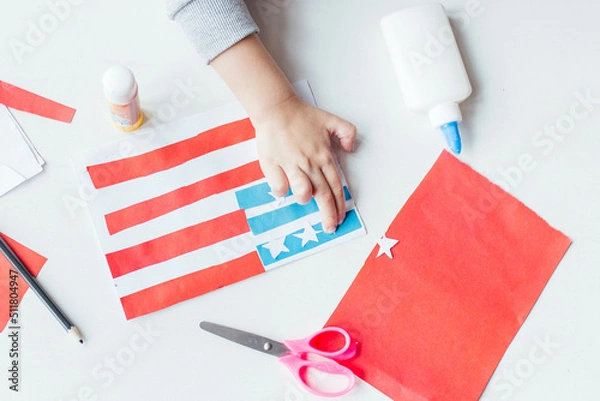 Fototapeta Step-by-step instruction. Child makes a postcard to the 4th of July. Patriotic holiday. Process kid children craft.USA Independence Day. Diy 4th of July decor color American flag. Flat lay top view