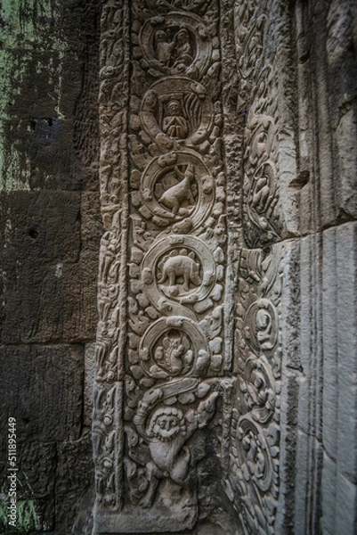 Fototapeta An ancient sandstone carving beside an arch that looks like a dinosaur at Ta Prohm Temple in Siem Reap Angkor Wat, Cambodia.