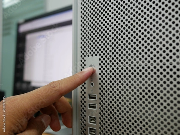 Obraz finger pushing on start button office computer PC.

