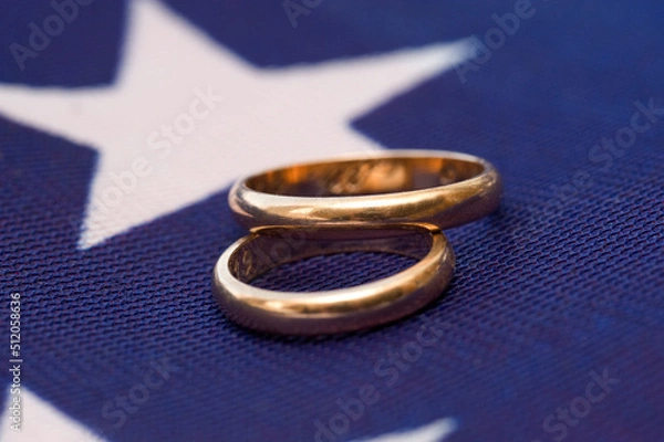 Obraz two gold wedding rings on a colored background