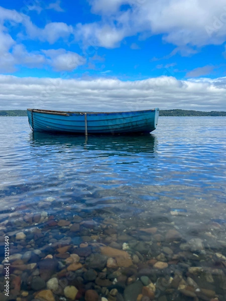 Obraz blue boat on the calm salty water