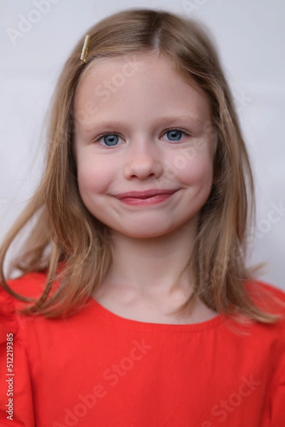 Fototapeta Little smiling girl posing and looking at camera with gladness