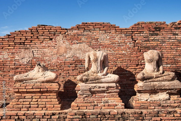 Obraz Broken ancient Buddha statue with bricks background.