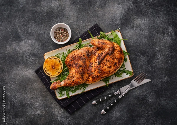 Obraz Grilled chicken. A half baked chicken with lemon and spices baked in the oven. Delicious juicy chicken. Grilled poultry