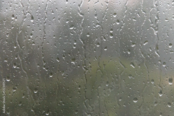 Fototapeta Raindrops drip down on the window glass. Soft selective focus.