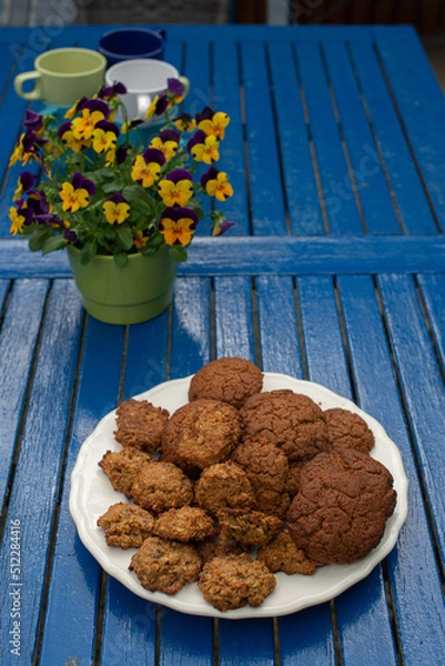 Fototapeta Cookies and yellow flowers are on the blue table.