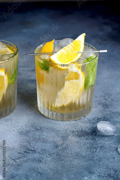 Fototapeta citrus lemonade with mint and lemon in the glass with ice cubes.