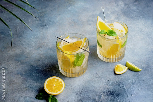 Fototapeta citrus lemonade with mint and lemon in the glass with ice cubes.