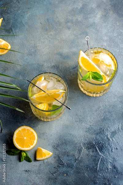 Fototapeta citrus lemonade with mint and lemon in the glass with ice cubes.