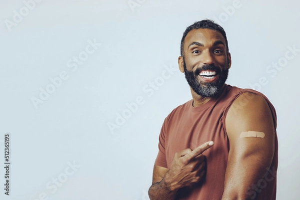 Obraz portrait mid adult bearded vaccinated man looking at camera pointing at plaster studio shot