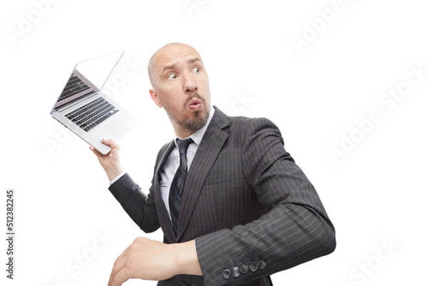 Obraz A man in suit not happy with the result throws a laptop isolated on white background.