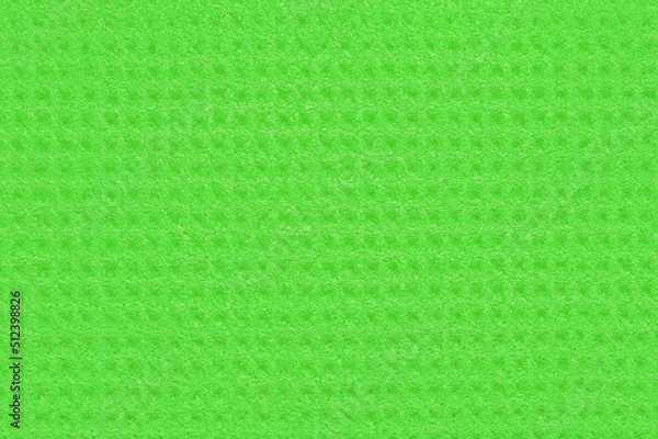 Fototapeta Porous green background from a kitchen sponge with a square ornament. Green synthetic background with symmetrical ornament and chaotic pores close-up. Free space for ads and text