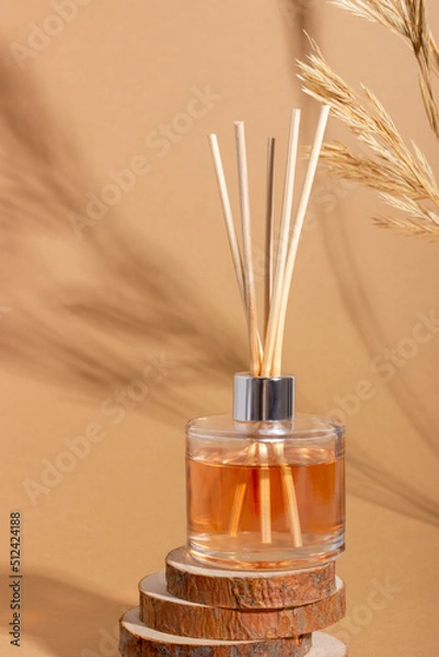 Fototapeta reed diffuser bottle on the podium. Incense sticks for the home with a floral scent with hard shadows. The concept of eco-friendly fragrance for the home