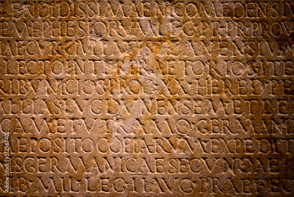 Fototapeta Latin text written in stone. Full frame Roman text carved into a flat stone wall.