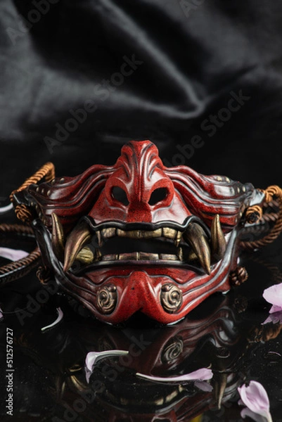 Obraz photo on a dark background of a samurai mask in the form of a demon mask
