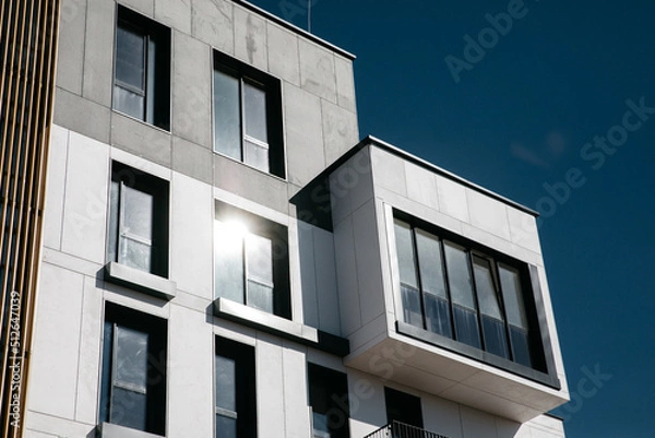 Obraz Modern apartment buildings Facade with a blue sky. Glass surface with sunlight.