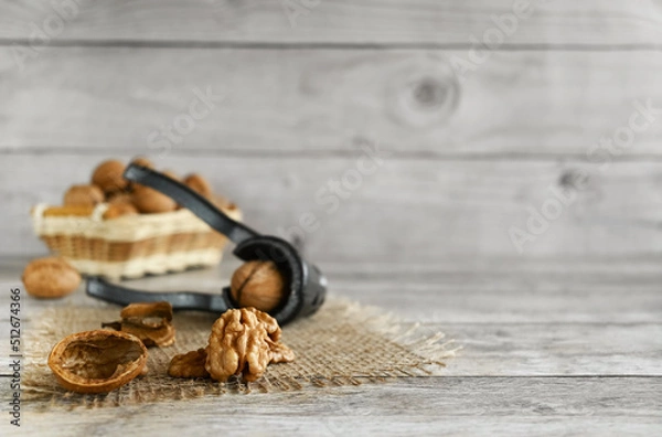 Fototapeta Walnuts are split on a wooden table, copy space. They contain B vitamins, vitamin C, vitamin PP, vitamin A, vitamin E; minerals sodium, potassium, iron, magnesium, iodine, zinc, cobalt
