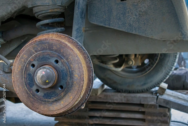 Fototapeta car without a wheel, close-up of a rusty brake disc