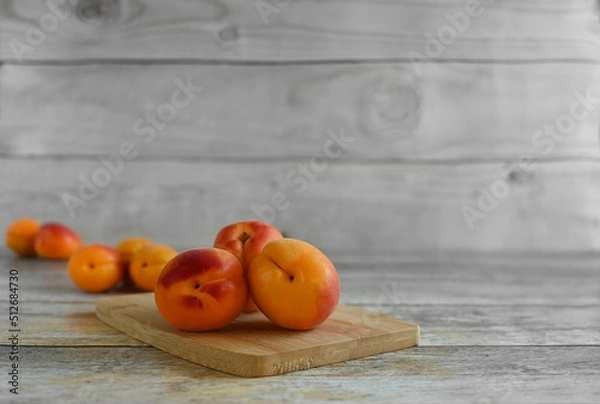Fototapeta Fresh ripe apricots on a wooden table, copy space . Apricots are rich in vitamins and minerals such as: vitamin A, beta-carotene, vitamin C, potassium, silicon, cobalt, manganese, copper