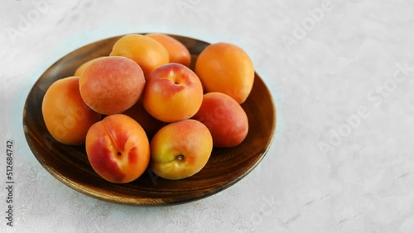 Fototapeta Bowl of fresh ripe apricots  on a wooden table, copy space