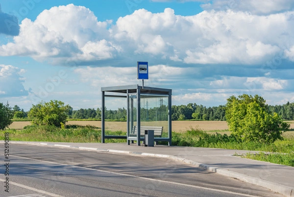 Fototapeta Empty bus stop by the field.