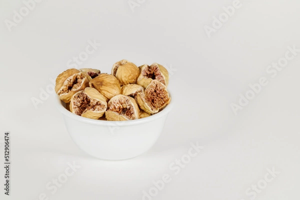 Fototapeta Closeup view of a bowl of dried figs on a white background