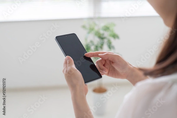 Obraz スマホやSNS運用をする女性の手元