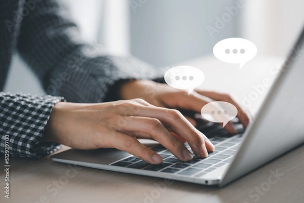 Obraz closeup woman hands typing on laptop with message icon as chatting