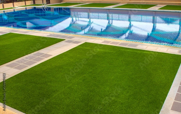 Fototapeta Green the artificial turf by the pool