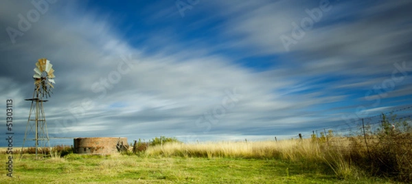 Obraz long exposure image with windmill and streaky clouds