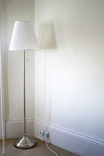 Fototapeta A large white lamp against a white wall. Empty room with a lonely lamp. Design.