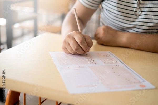 Obraz student filling in exam paper by hand