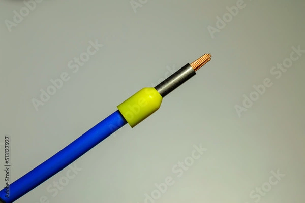 Fototapeta Blue wire with yellow ferrule - macro photo. Background picture. Selective focus.