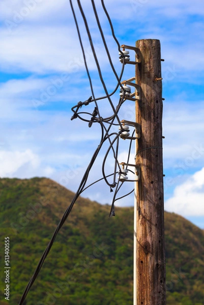 Fototapeta Countryside Power Supply Line Detail / Old wooden pole of power transmission at rural area with cables and ceramic insulators (copy space)