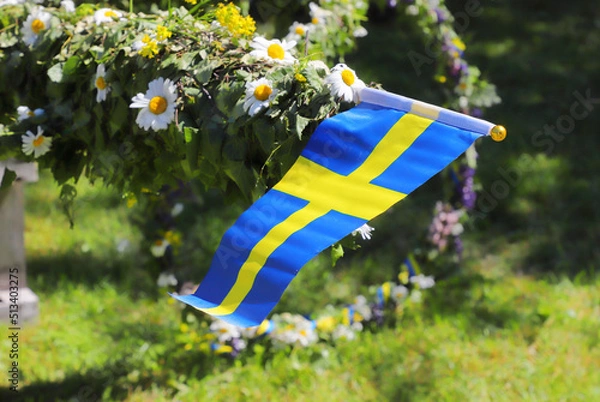 Obraz Traditional midsummer pole with Swedish flag awaits the rising ceremony.