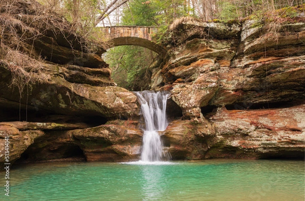 Obraz Cascading waterfall flowing under arch bridge in Hocking Hills State Park, Ohio. 